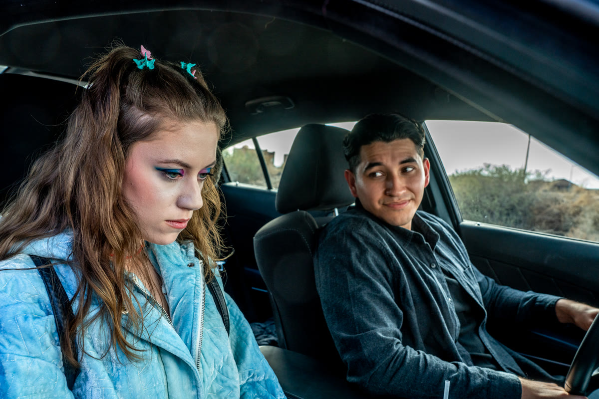 Still from Homecoming: a teen girl sits in a car beside a young man