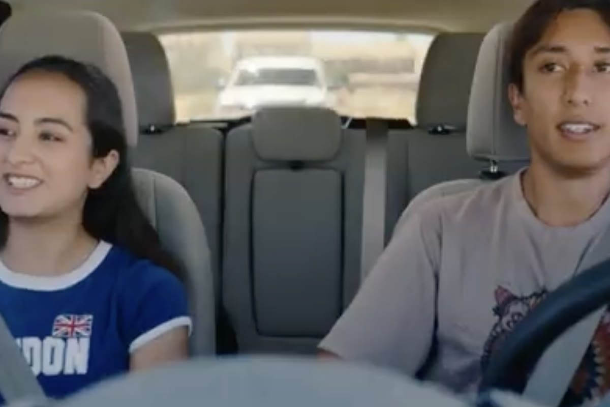 Still from United We Stand: two teens laugh together in a car